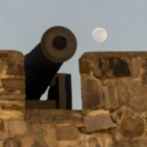 A cannon with the moon in the background.