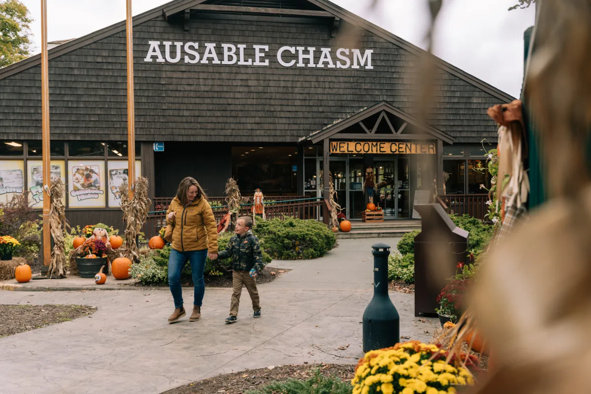 A woman walks with her son from a gift shop at a fall attractions.
