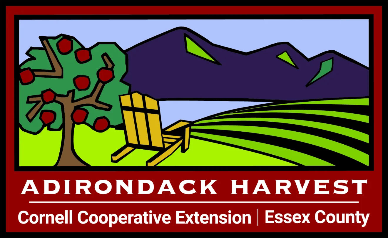A sign that reads "Adirondack Harvest, Cooperative Extension, Essex County" with a graphic of farmland and mountains above.