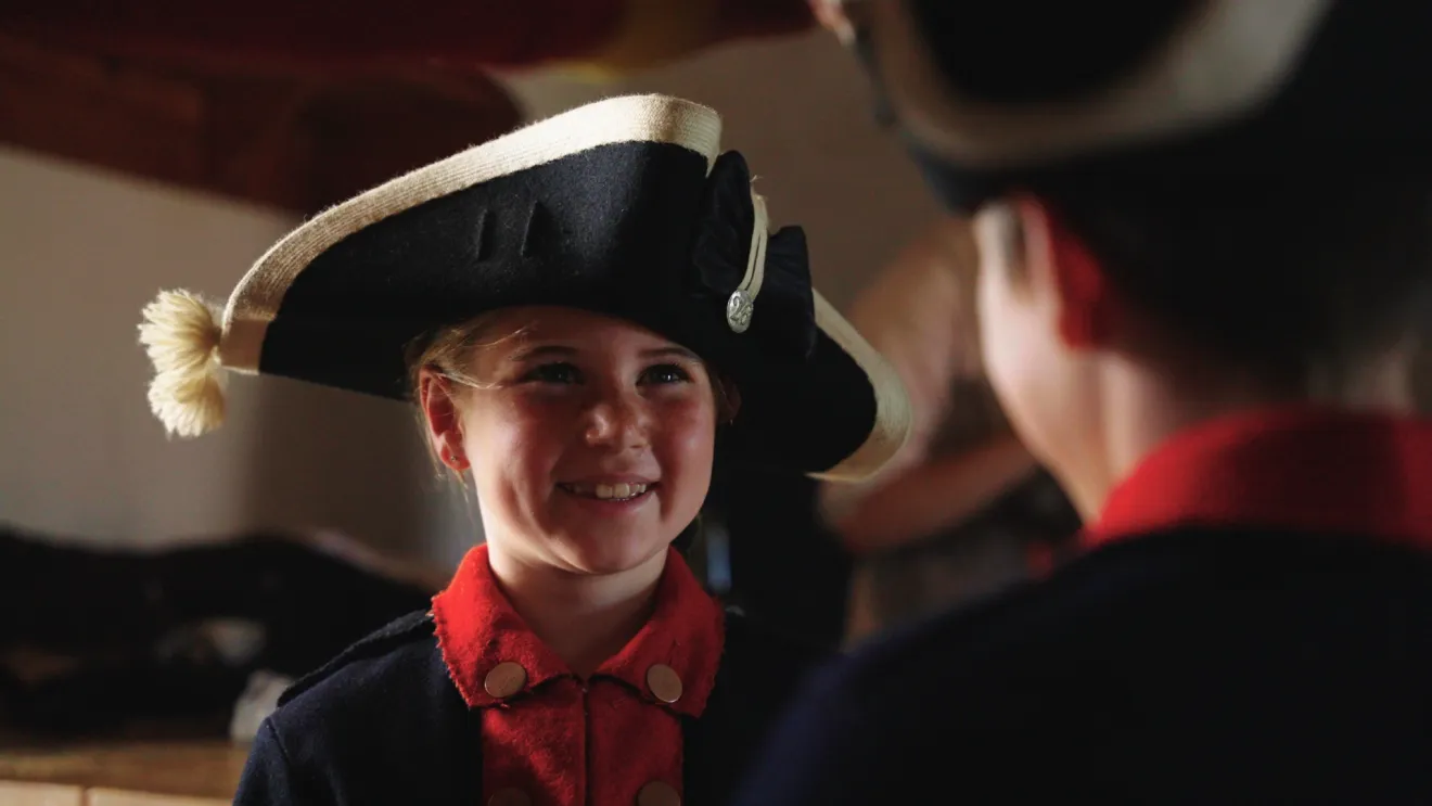 Close-up of a child dressed up in the tricorn hat of a Revolutionary War soldier.