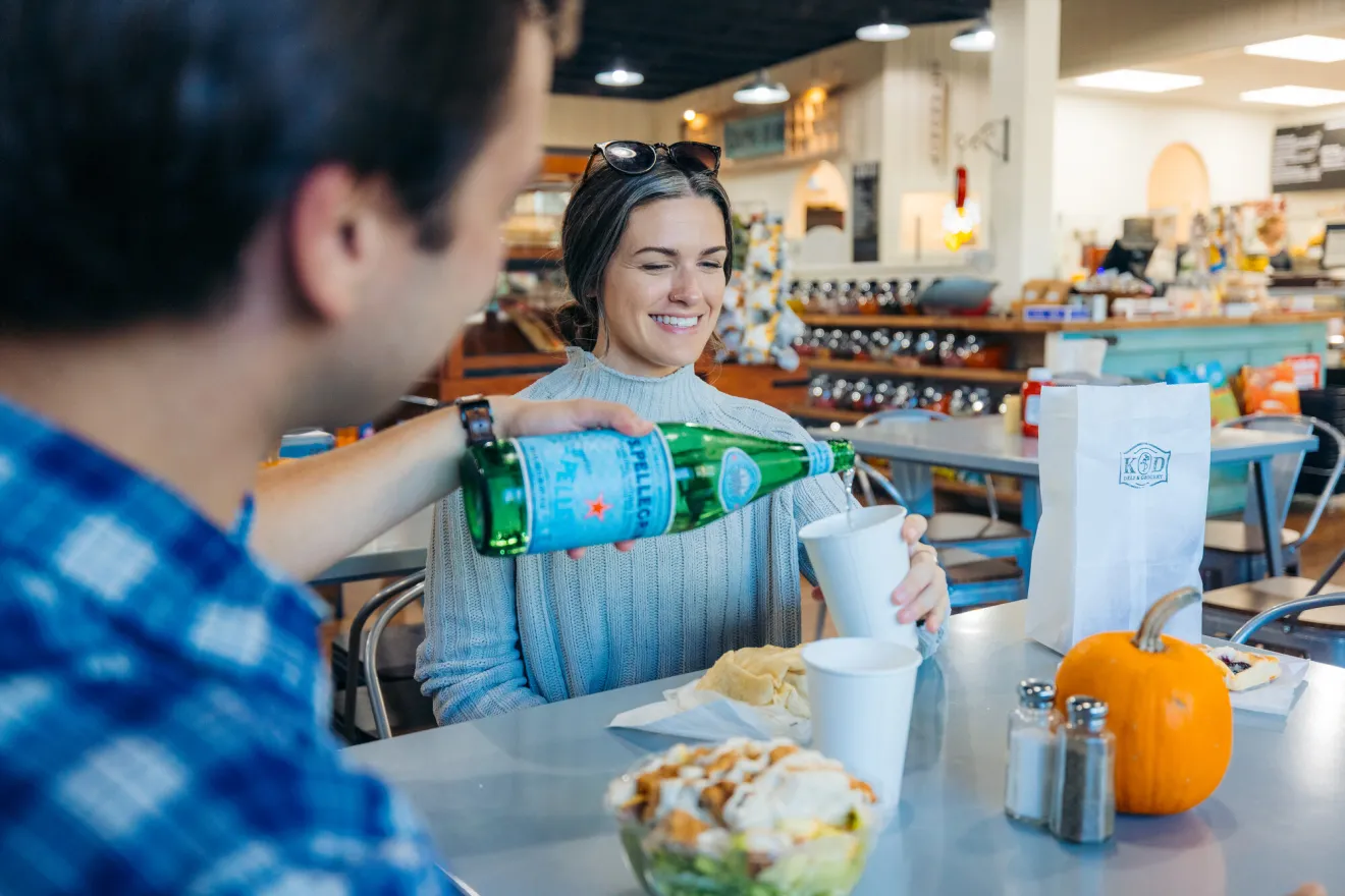 A man and woman eat at a deli.
