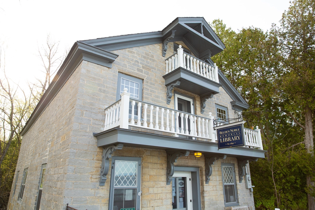 A three story building made of stone blocks with three balconies.