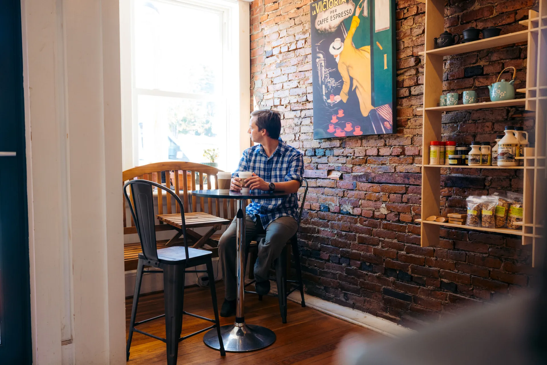 A guy drinking coffee at Jambs on Main coffee shop
