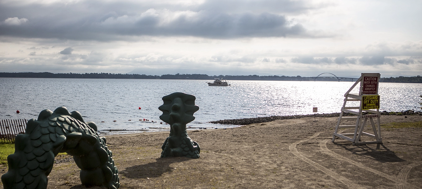 A statue of Champy slithers through the sand.
