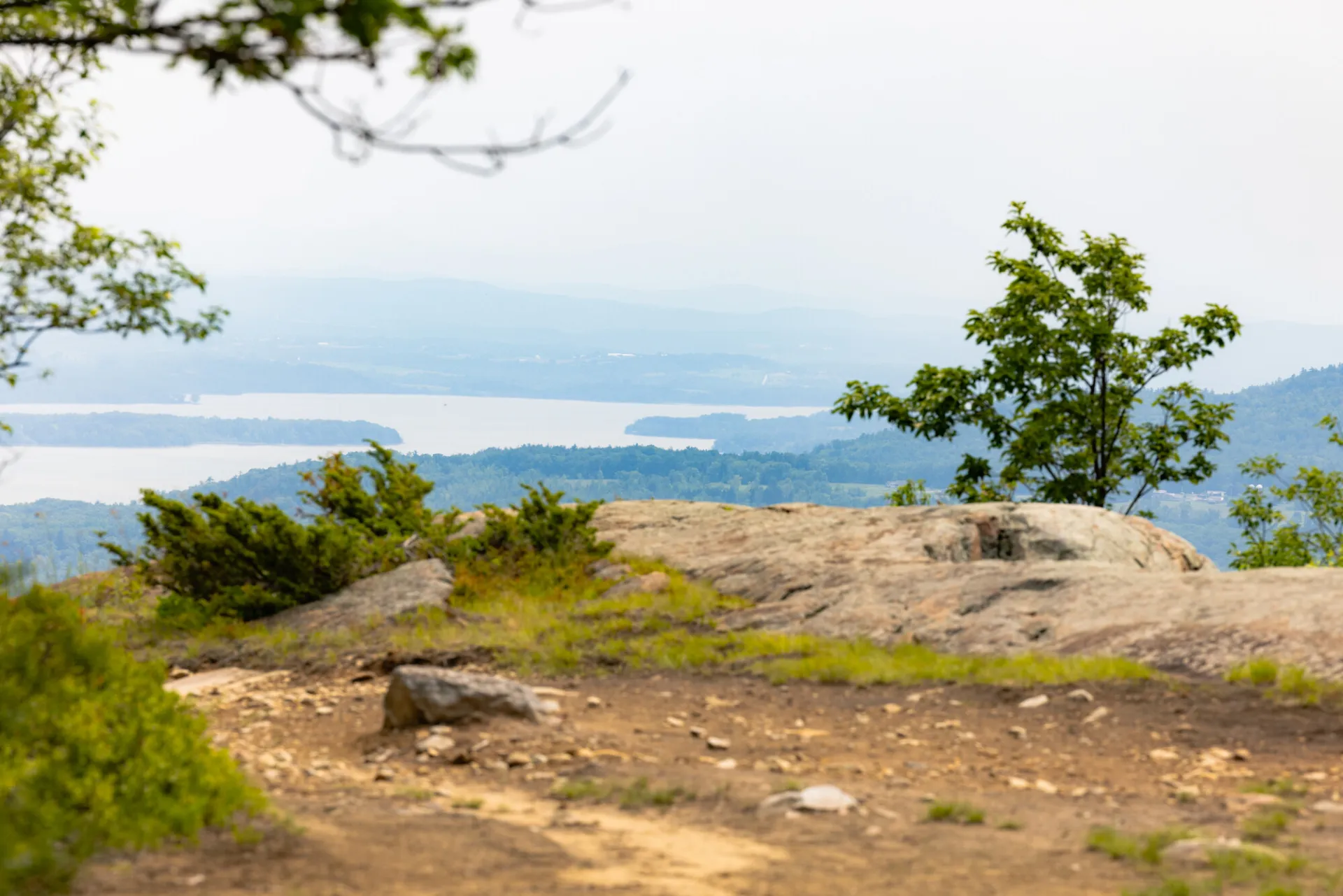 An open summit looking out towards narrow Lake Champlain.