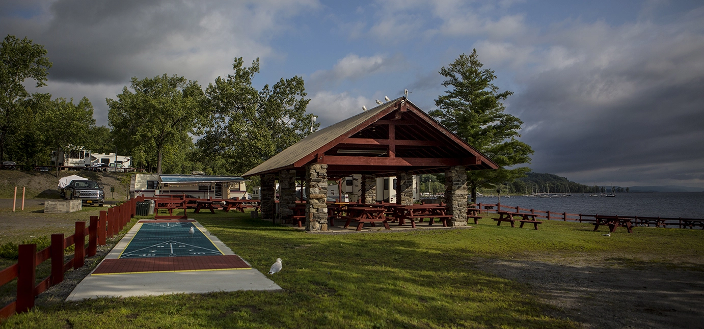 A large stone pillar and wood beamed gazebo.