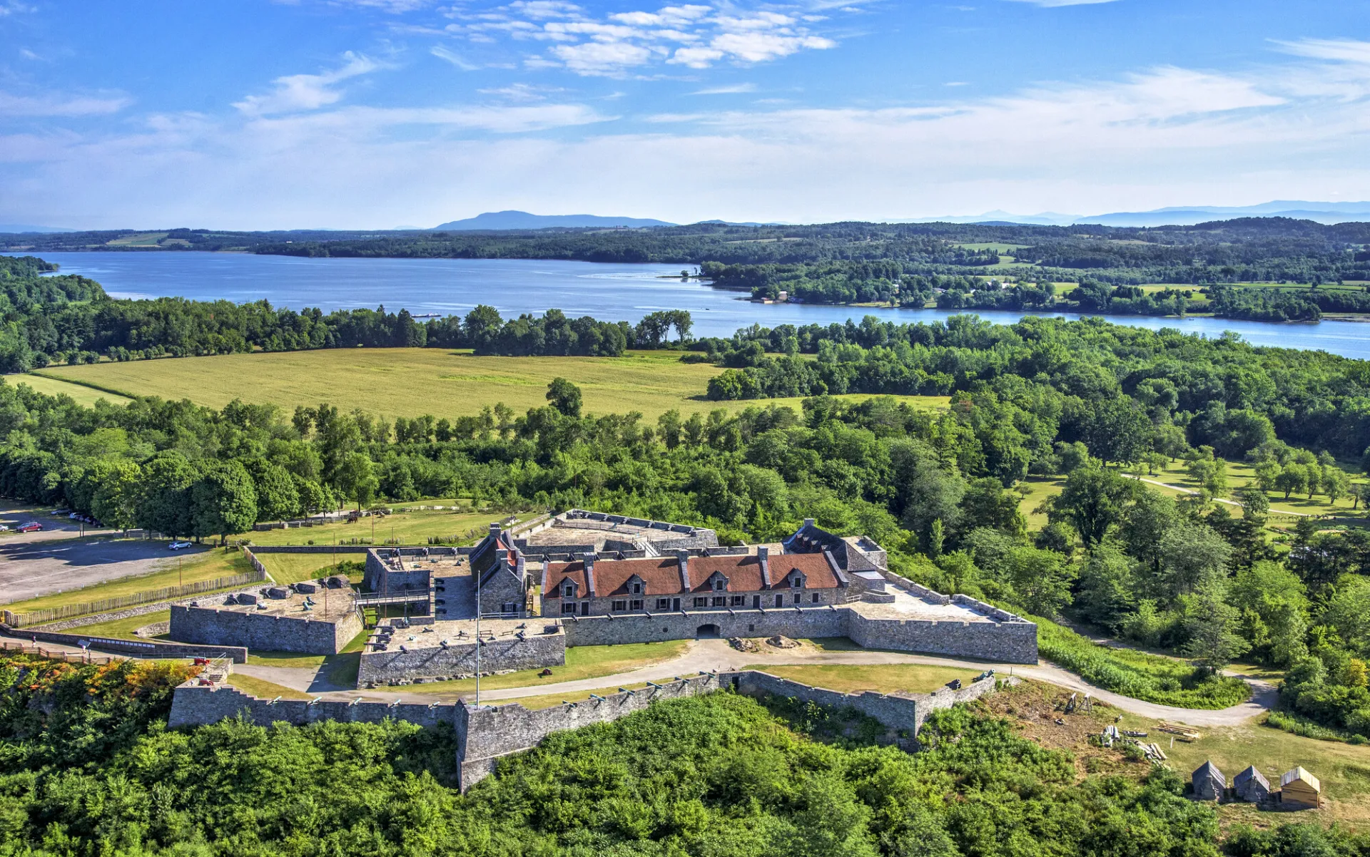 An aerial view of a star-shaped stone fort on a low wooded hill.
