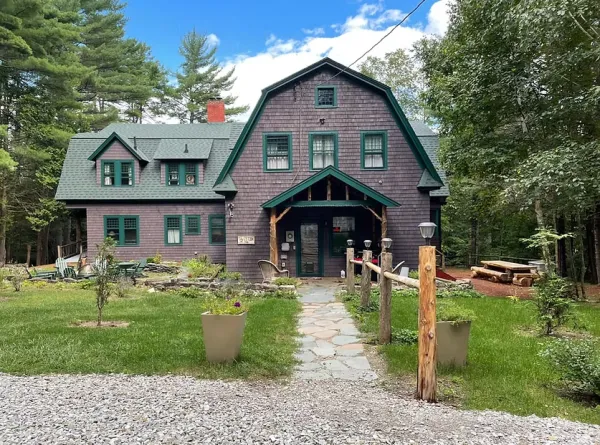 picture of the front of the Tavistock Lodge. Brown Building with Green Roof 