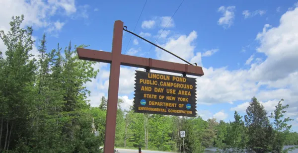 A yellow and brown sign marking a campground entrance.