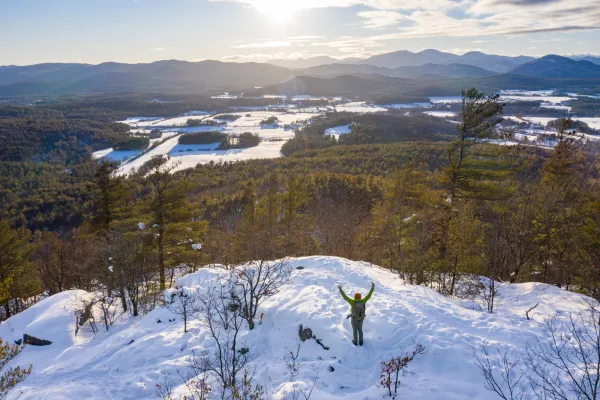 A person on the summit of Coon Mountain in the winter.
