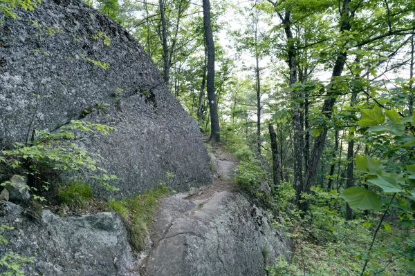 A trail winds around a slabby rock