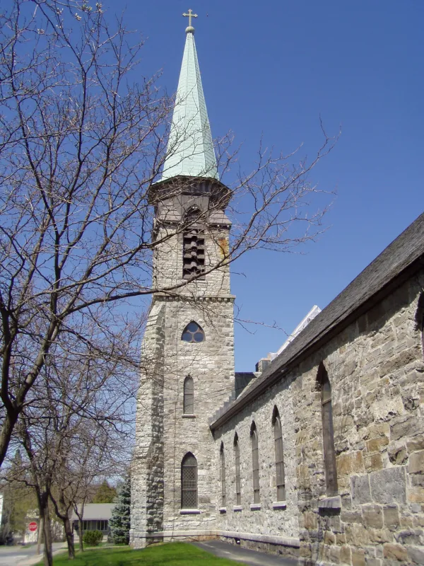 Stone steeple of a large church and a patinaed copper topper