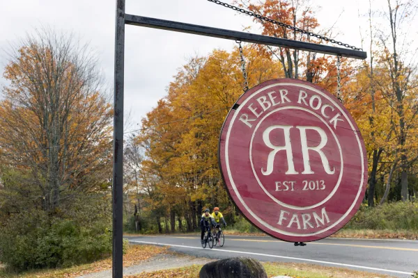 A round, red sign for Reber Rock Farm