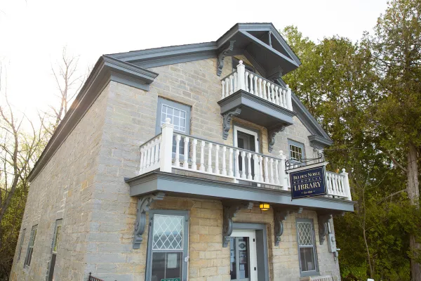 A three story building made of stone blocks with three balconies.