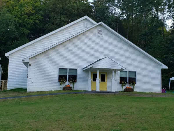 A white church with flower boxes and yellow doors.