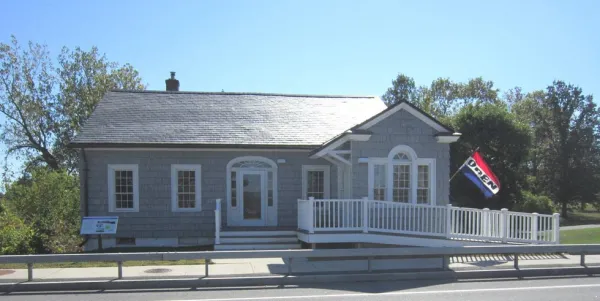 The entry to the grey building with white trim with entry ramp of the former bridge toll house, now visitors center.