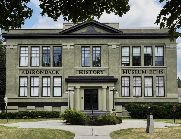 The front exterior of the large stone building of the Adirondack History Museum.