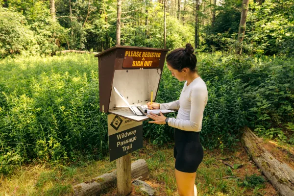 A hiker registering in a logbook