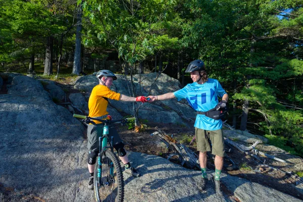 Two mountain bikers fist bump