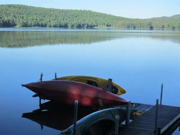 A dock with some kayaks on a pond