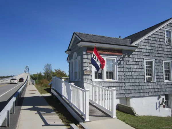 The entry to the grey building with white trim with entry ramp of the former bridge toll house, now visitors center.