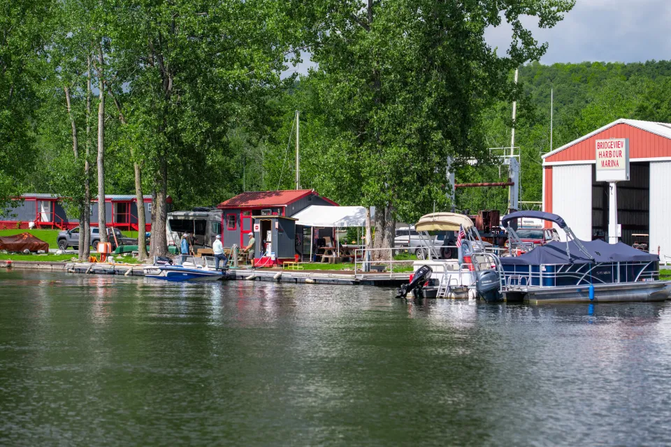 A group of cabins and boats park on the water of a lake.