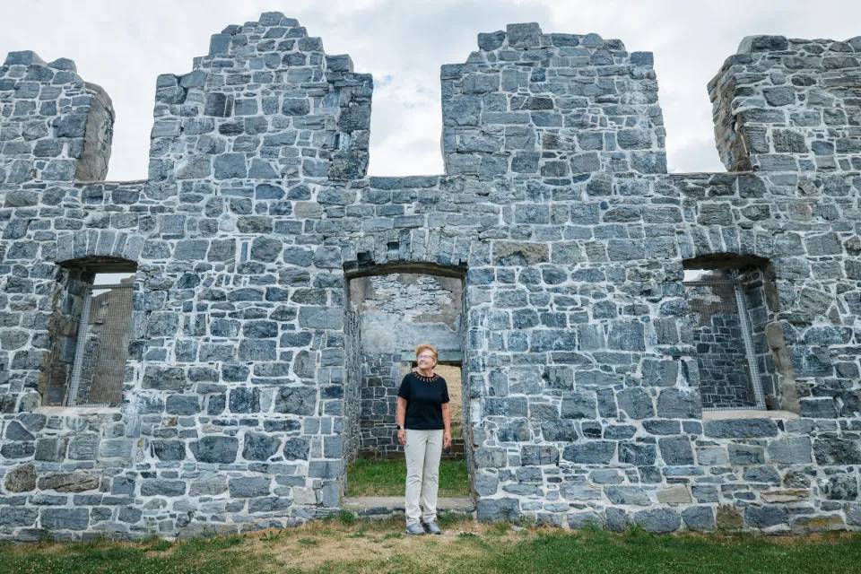 A woman walks through ruins at a historic site.